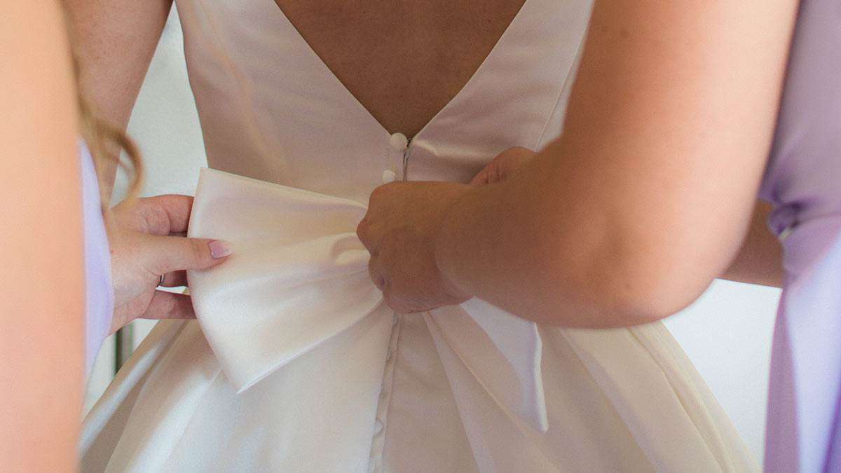 sposa si fa aiutare da damigelle per vestizione